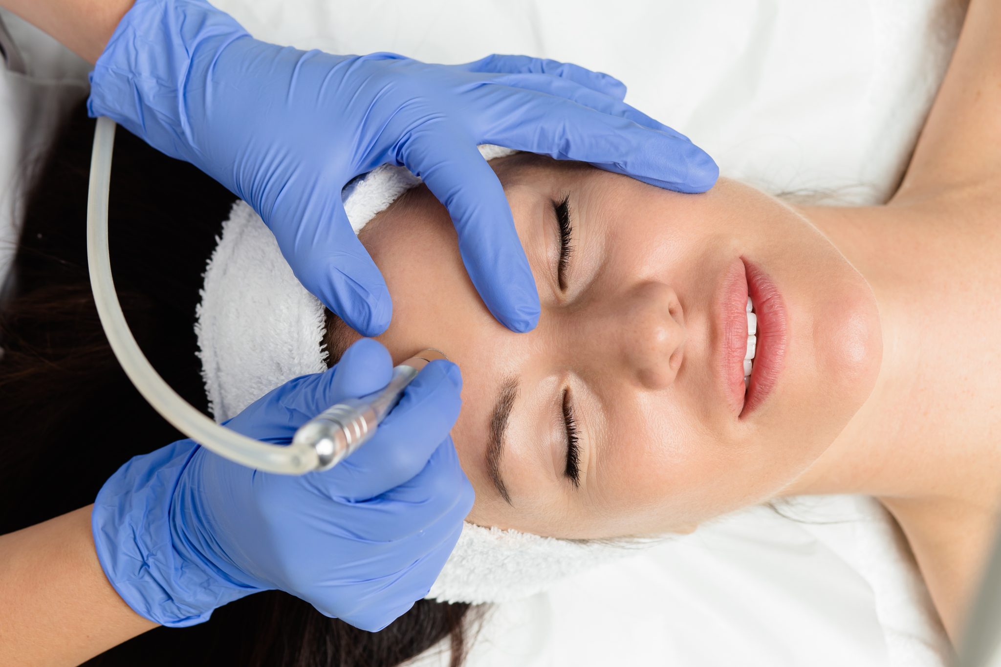 Beautiful woman getting facial microdermabrasion peeling treatment at luxury cosmetic beauty spa clinic. Exfoliation, rejuvenation and hydratation. Cosmetology concept. The doctor cosmetologist makes Lip augmentation procedure of a beautiful woman in a beauty salon
